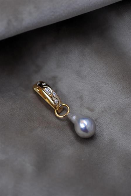 Vigselring som är omarbetad till ett hängsmycke med en grå pärla för det lilla extra.
