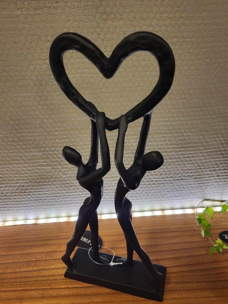 Smidesfigur par håller hjärta