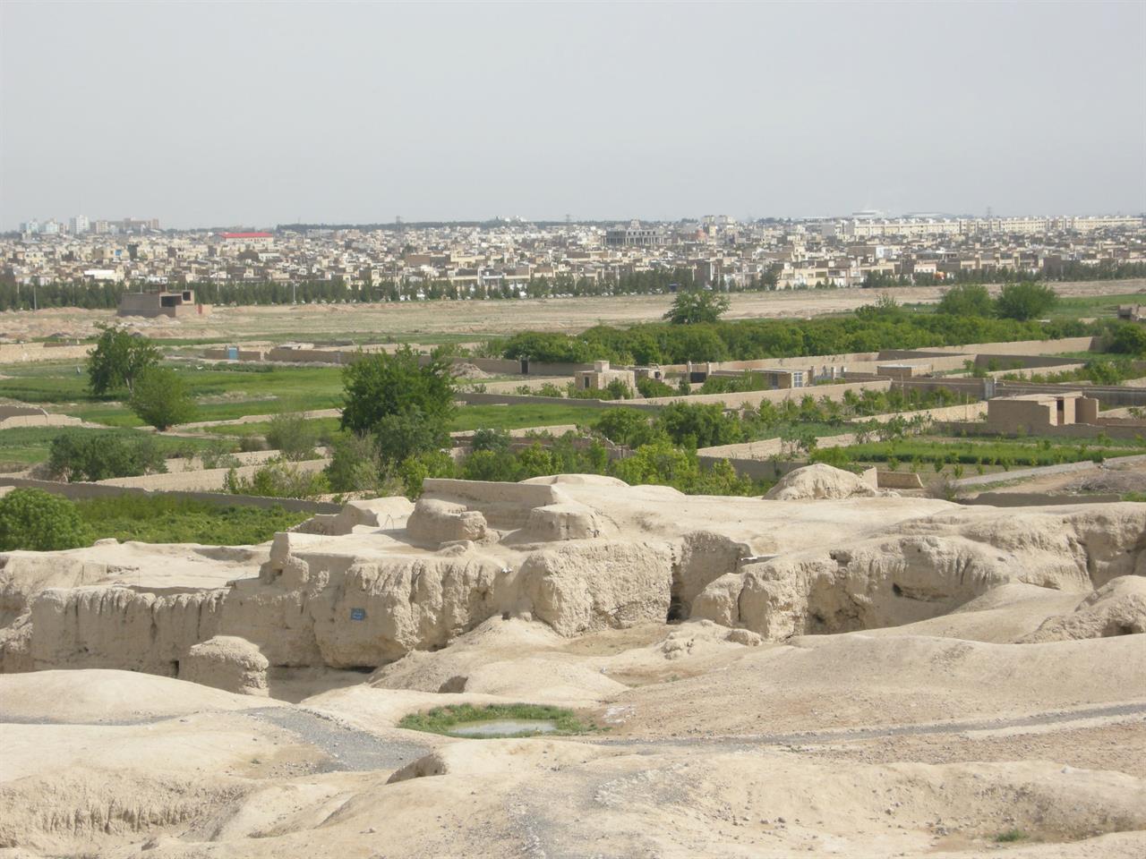 Utsikt fra de 4000 år gamle ruinene Teppe Sialk mot frukthager og boligstrøk i Kashan, Iran