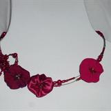 5. Halsband i rött av textil, metalltråd och pärlor
