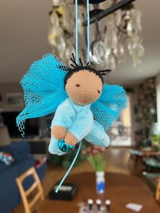 Liten turkos skyddsängel med svart tofs o mörk hy