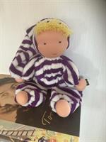 Mellanbarn med luva i lila ränder och blond lugg