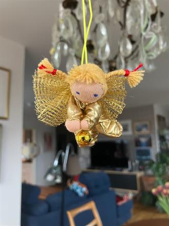Liten gyllene skyddsängel med blonda flätor