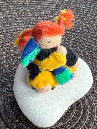 Minidocka på sten i randig velour med röda flätor