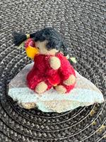 Miniwaldorf  på sten i rött, svarta flätor och mörk hy