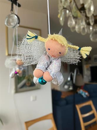 Liten silvrig skyddsängel med blonda flätor