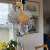 Liten silvrig skyddsängel med rågblond fläta