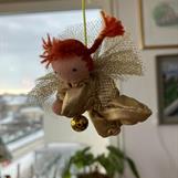 Liten gyllene skyddsängel med röda flätor