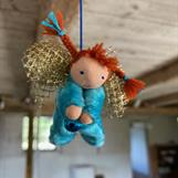 Liten turkos skyddsängel med röda flätor.  Klicka för att se mer eller beställa!