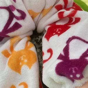 Mellanbarn i solgul velour med röd lugg  och vitmönstrad luva