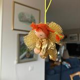 Liten gyllene skyddsängel med röda flätor