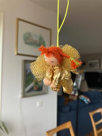 Liten gyllene skyddsängel med röda flätor