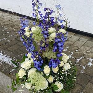 Stående dekoration med vita och blåa blommor