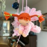 Liten ljusrosa skyddsängel med röda flätor
