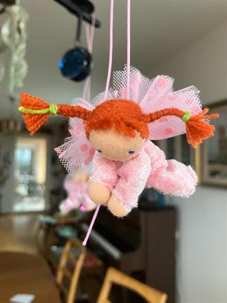 Liten ljusrosa skyddsängel med röda flätor