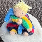 Minidocka på sten i randig velour o blond tofs