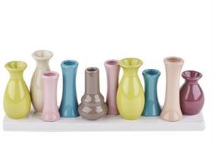 10 mini vaser på rad i olika färger.