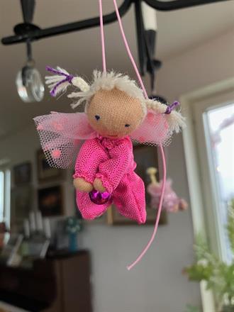 Liten ceriserosa skyddsängel med vita flätor