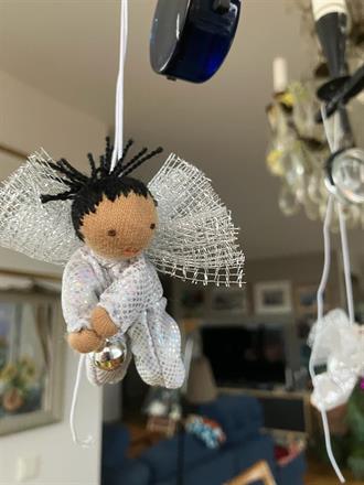 Liten silvrig skyddsängel med svart tofs o mörk hud