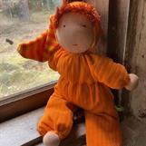 Stor orange kramdocka med randig luva och röd lugg