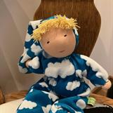 Mellanbarn i turkost med vita moln, ,luva och blond lugg