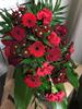 Begravningsbukett med blommor i röda färger 