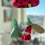 * Knyttdockan har dräkt och luva i röd velour med svarta prickar (e.g. nyckelpiga), håller i en guldkula
