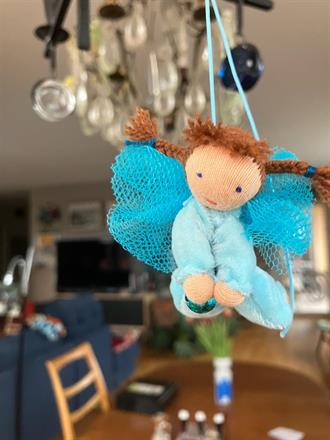 Liten turkos skyddsängel med ljusbruna flätor