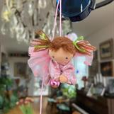 Liten ljusrosa skyddsängel med ljusbruna tofsar