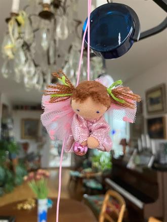 Liten ljusrosa skyddsängel med ljusbruna tofsar
