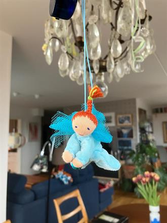 Liten turkos skyddsängel med röd fläta